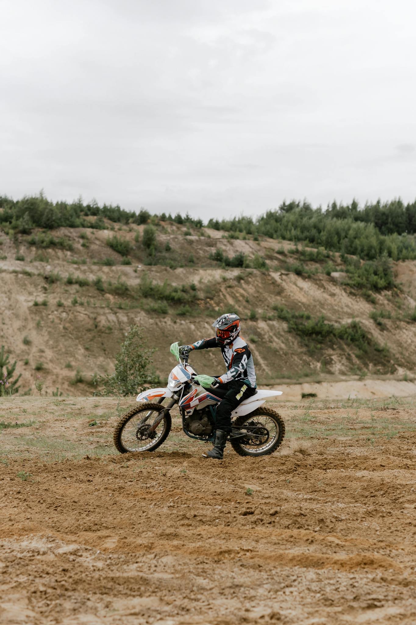 Man riding a dirt bike on an off-road trail, showcasing adventure and sport.